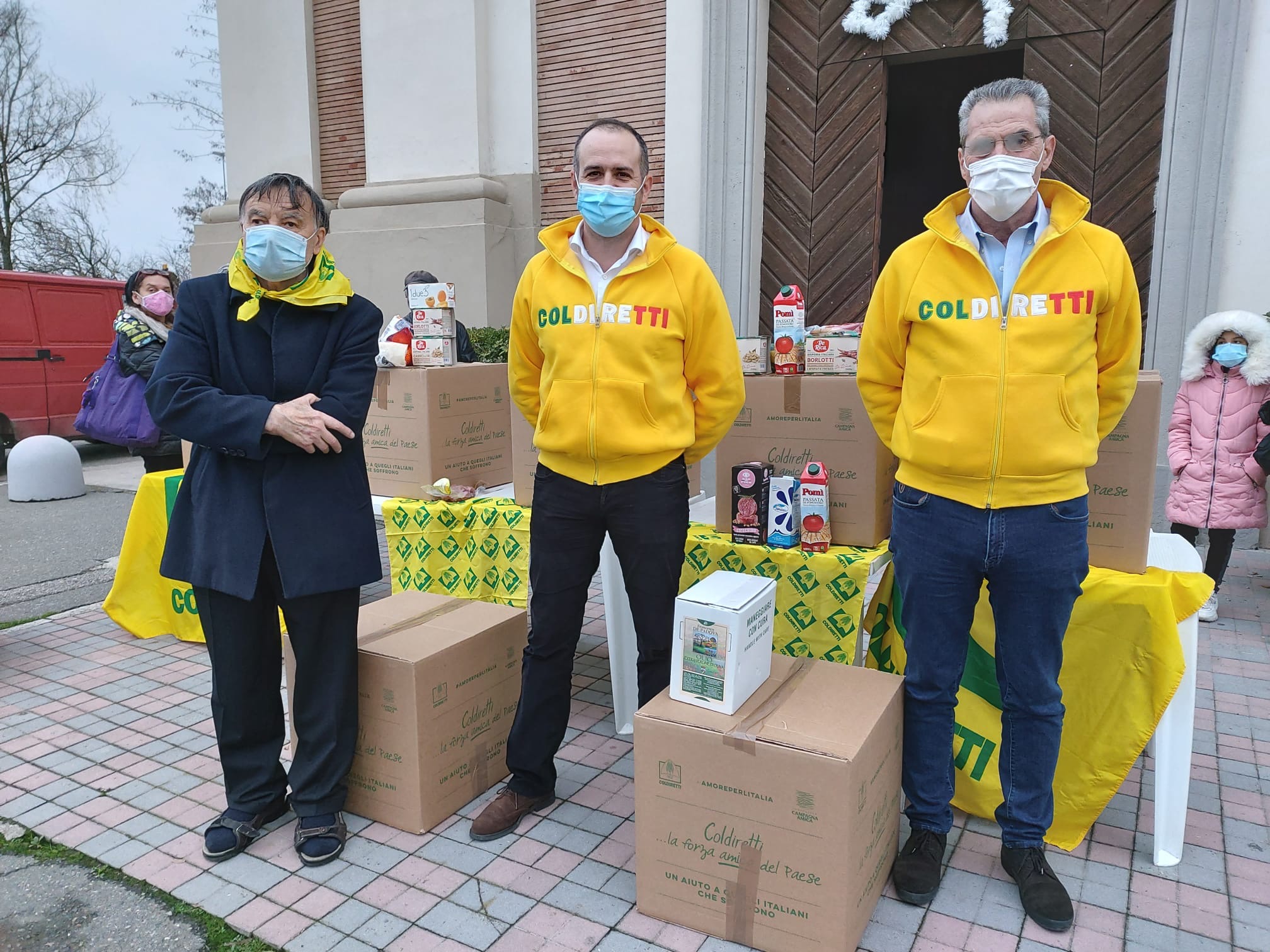 Il Presidente e il Direttore Coldiretti Alessandria Mauro Bianco e Roberto Rampazzo, a San Michele sul sagrato della parrocchia, con Mons. Ivo Piccinini consigliere ecclesiastico provinciale, durante la distribuzione dei pacchi contenenti generi alimentari 100% vero Made in Italy per aiutare le famiglie in difficoltà a trascorrere con un sorriso il Natale ormai alle porte.